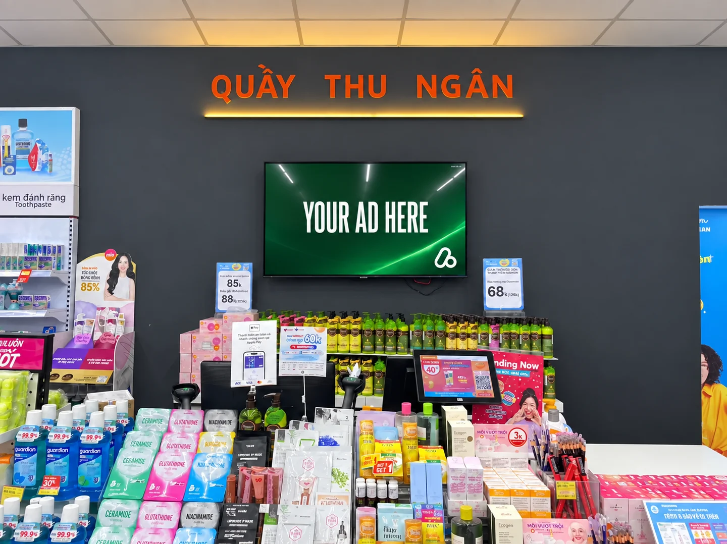 Retail media display above a Guardian checkout counter