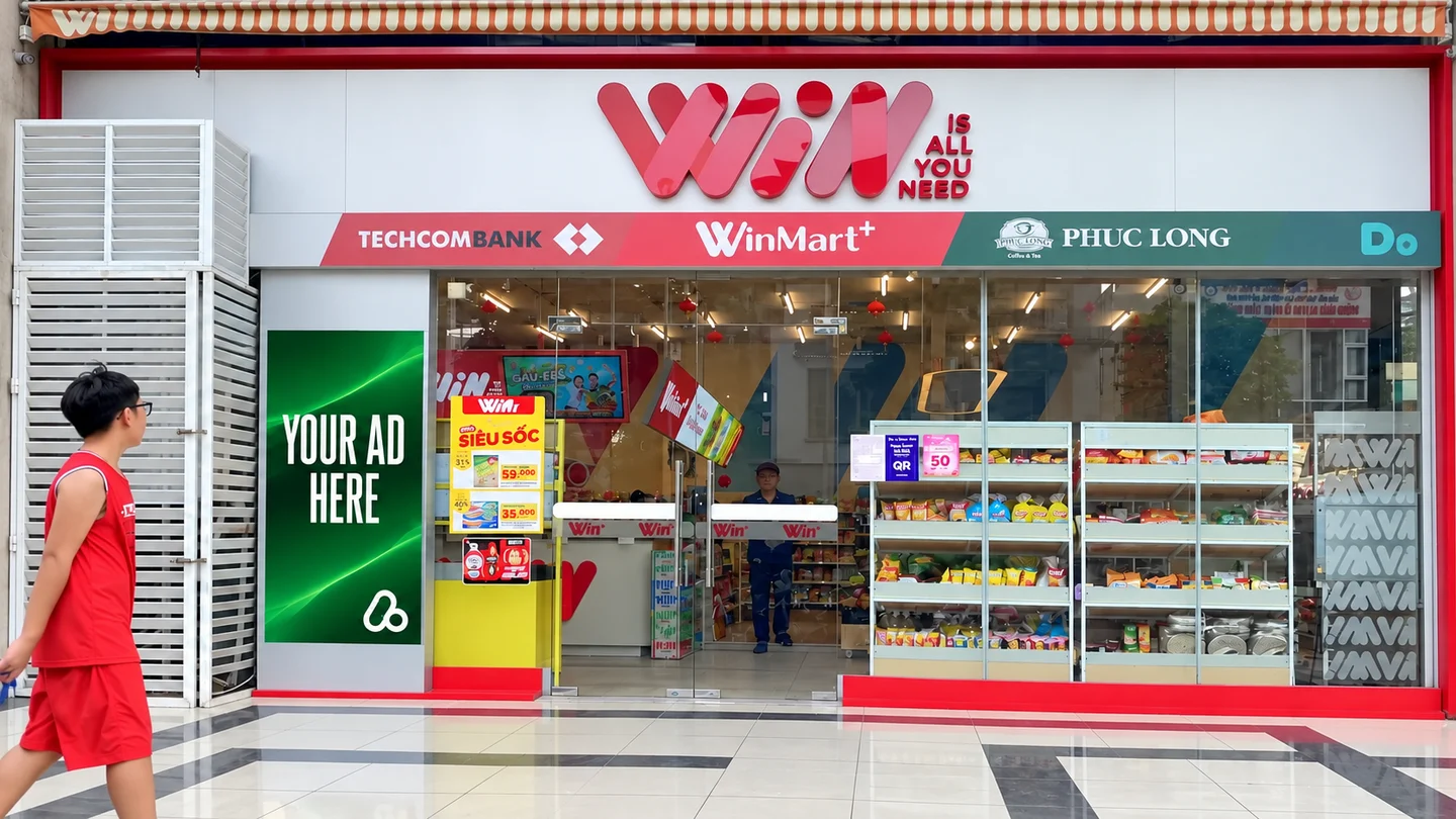Digital advertising display beside a WinMart+ store entrance